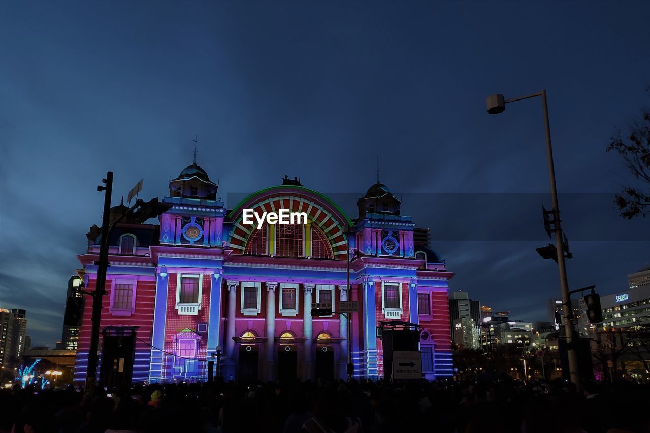 LOW ANGLE VIEW OF ILLUMINATED BUILDINGS AT NIGHT