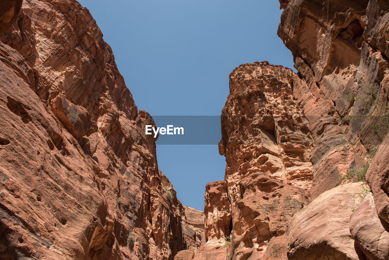 Low angle view of rocky mountains against sky