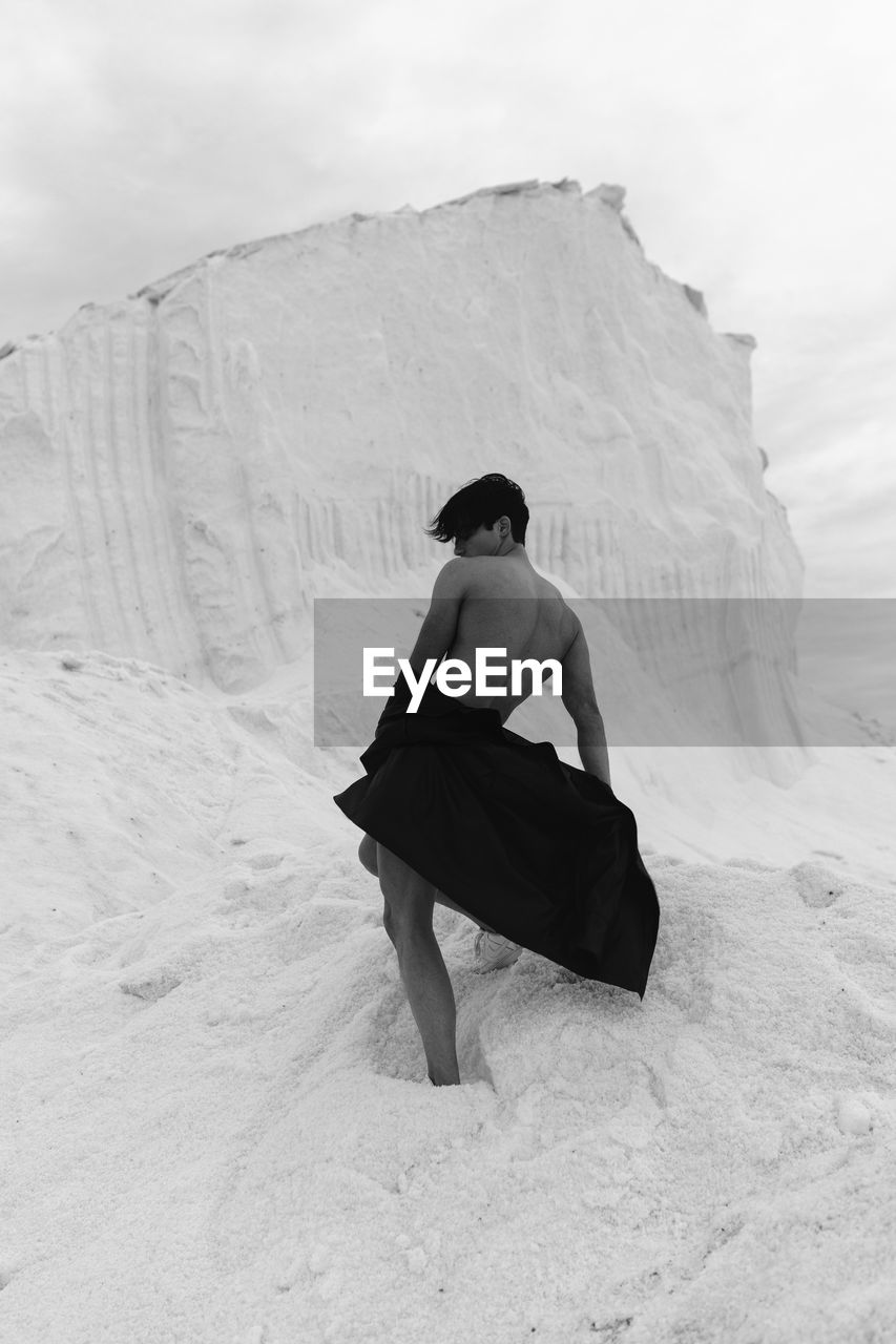 Rear view of a man standing on snow covered landscape