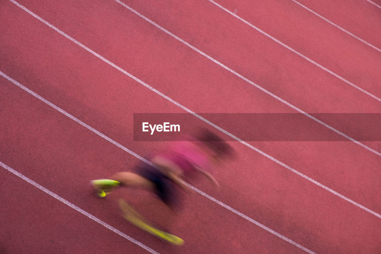 High angle blurred motion of athlete running on track