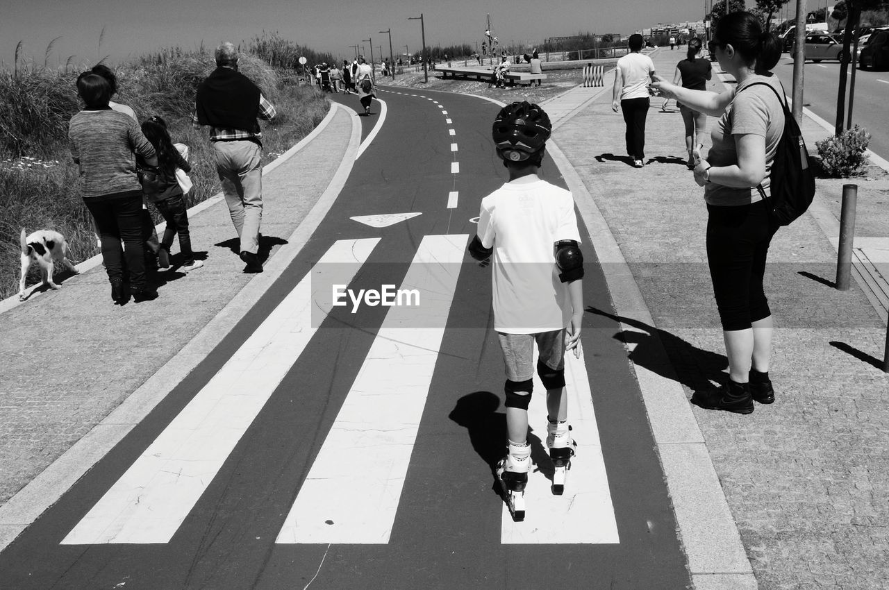 Rear view of people walking on road