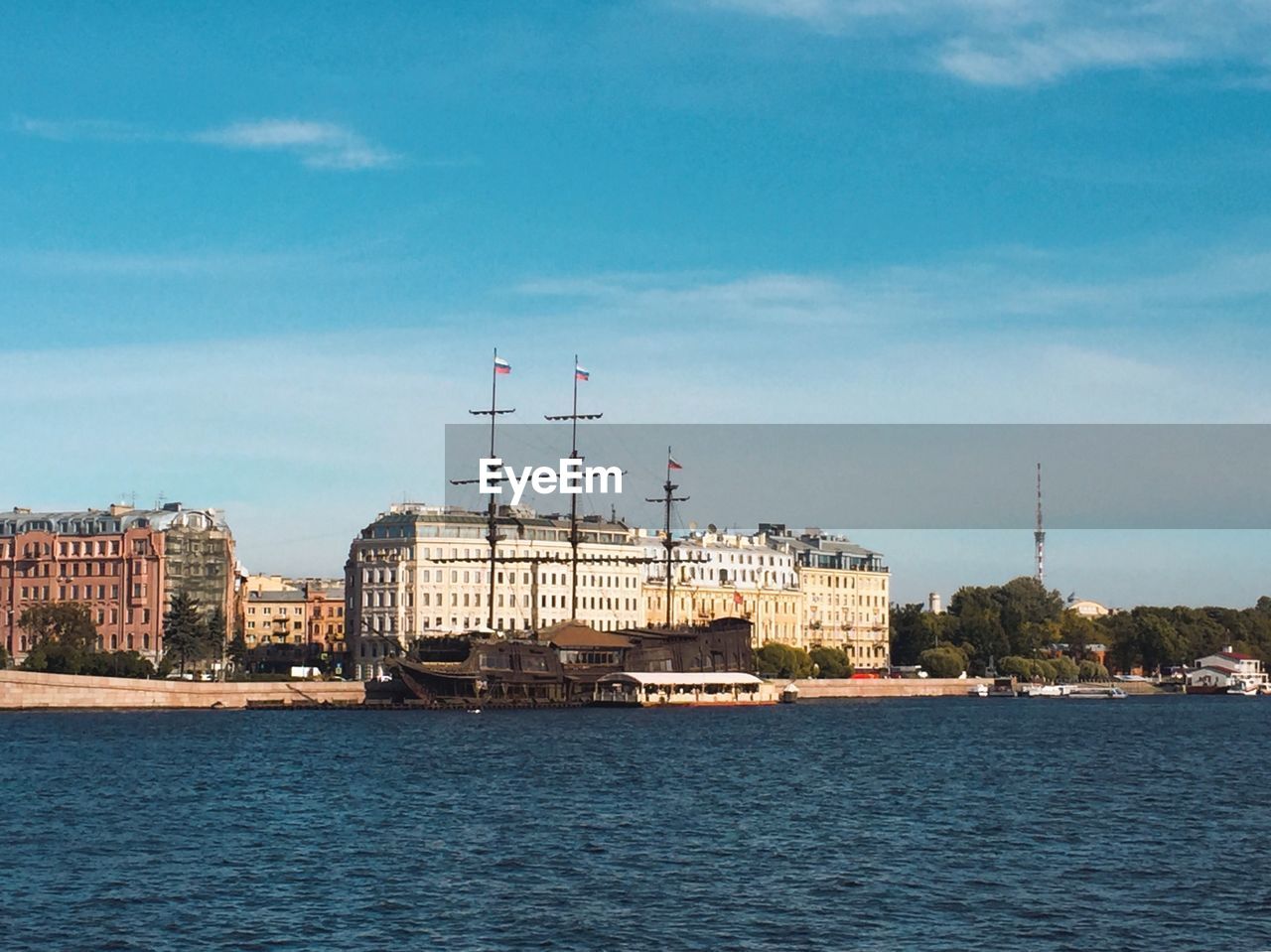 RIVER BY BUILDINGS AGAINST SKY