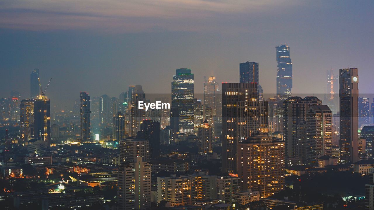 Illuminated cityscape against sky at night