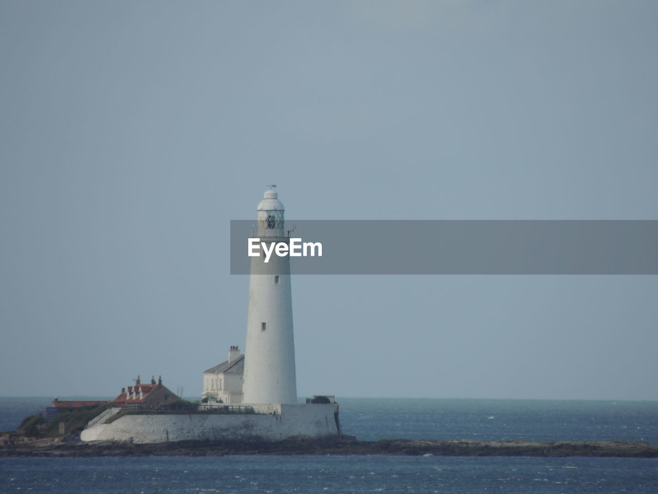 LIGHTHOUSE AMIDST SEA AGAINST SKY