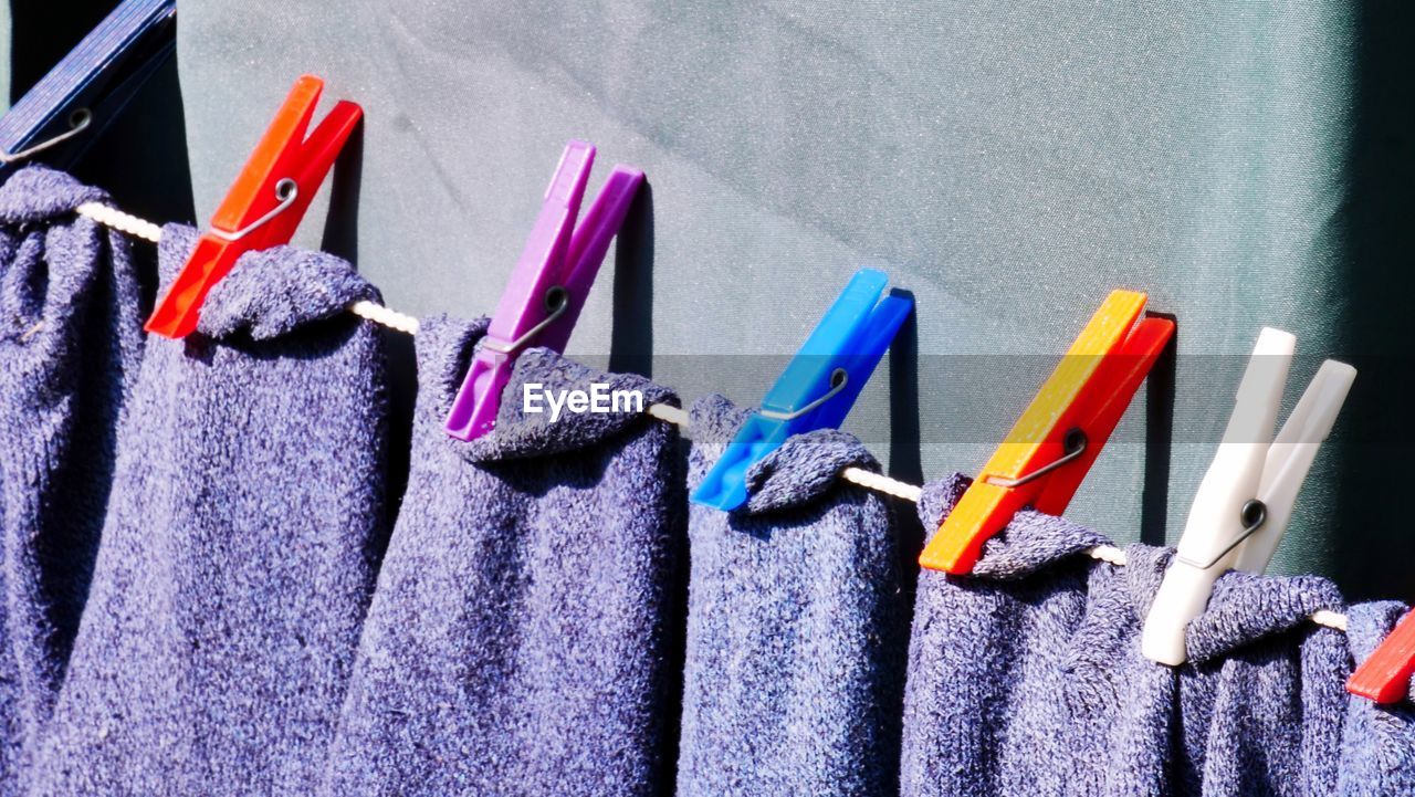Close-up of purple towels drying on clothesline