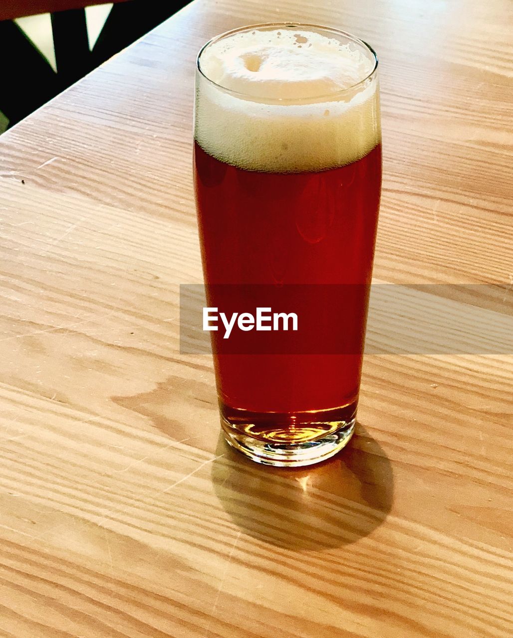 CLOSE-UP OF BEER ON GLASS TABLE