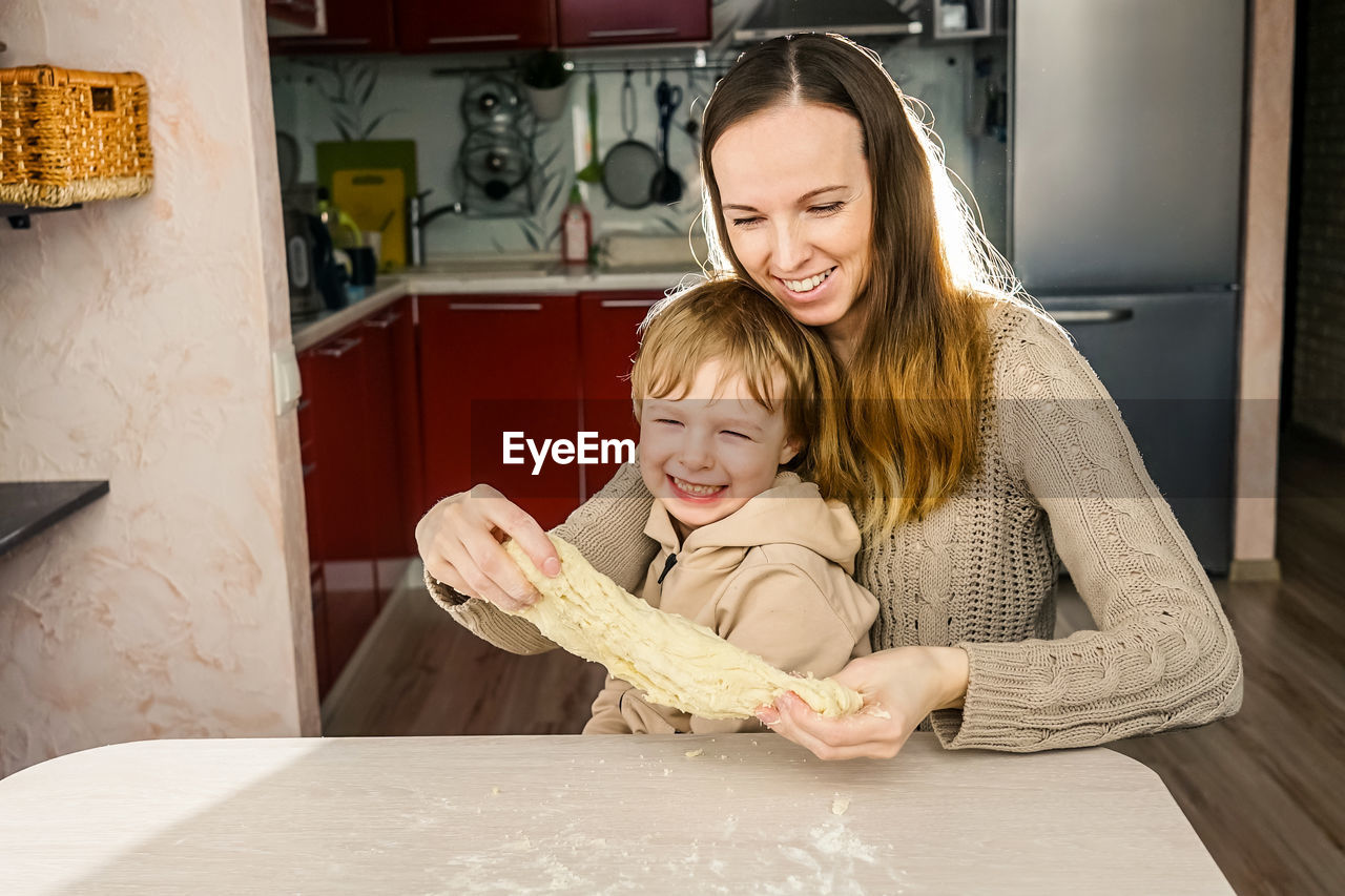 Mother and son preparing food on table