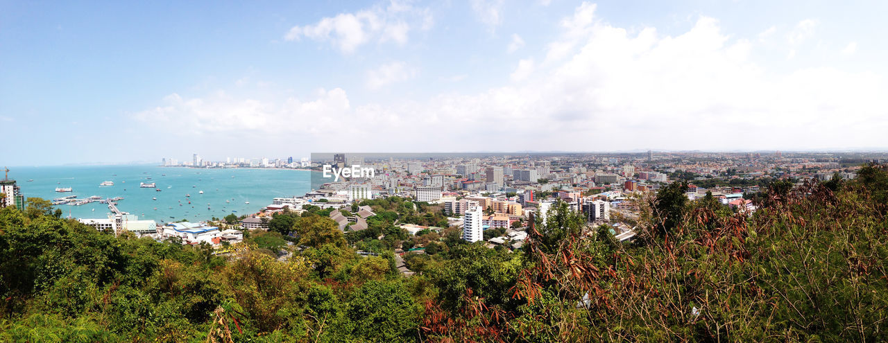 Panoramic view of sea and cityscape against sky
