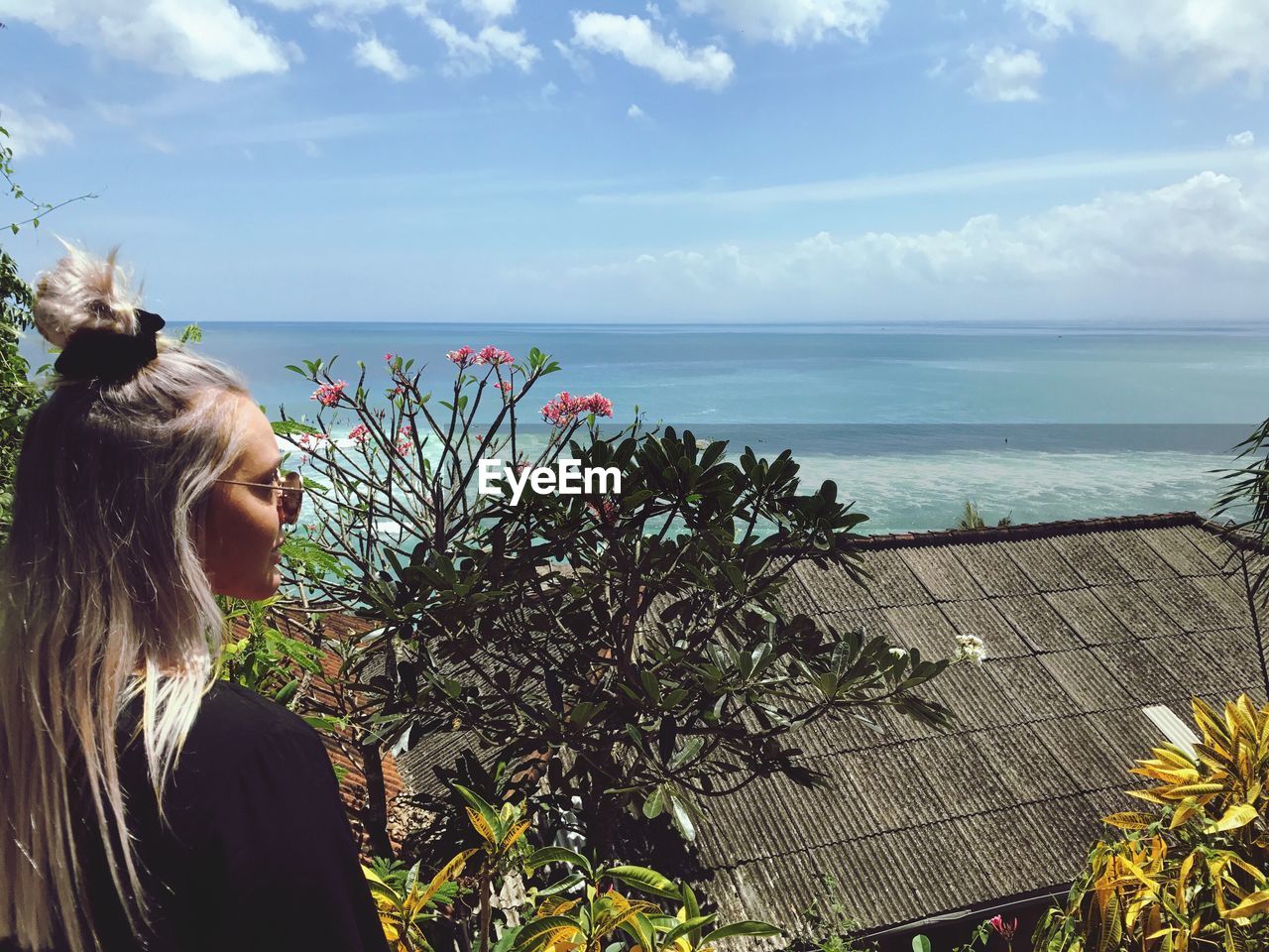 Beautiful woman looking at sea against sky