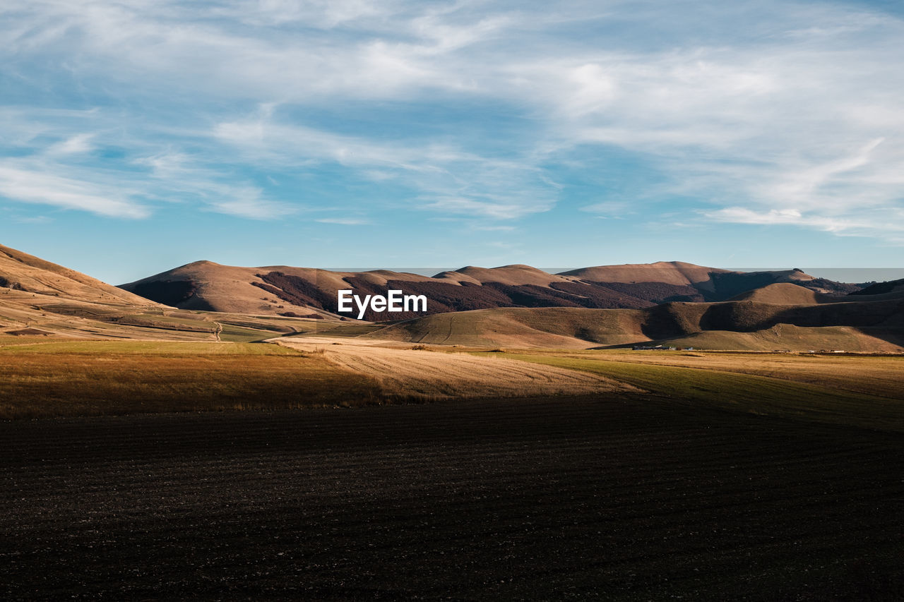 Scenic view of rocky mountains against sky in castelluccio, umbria italy 