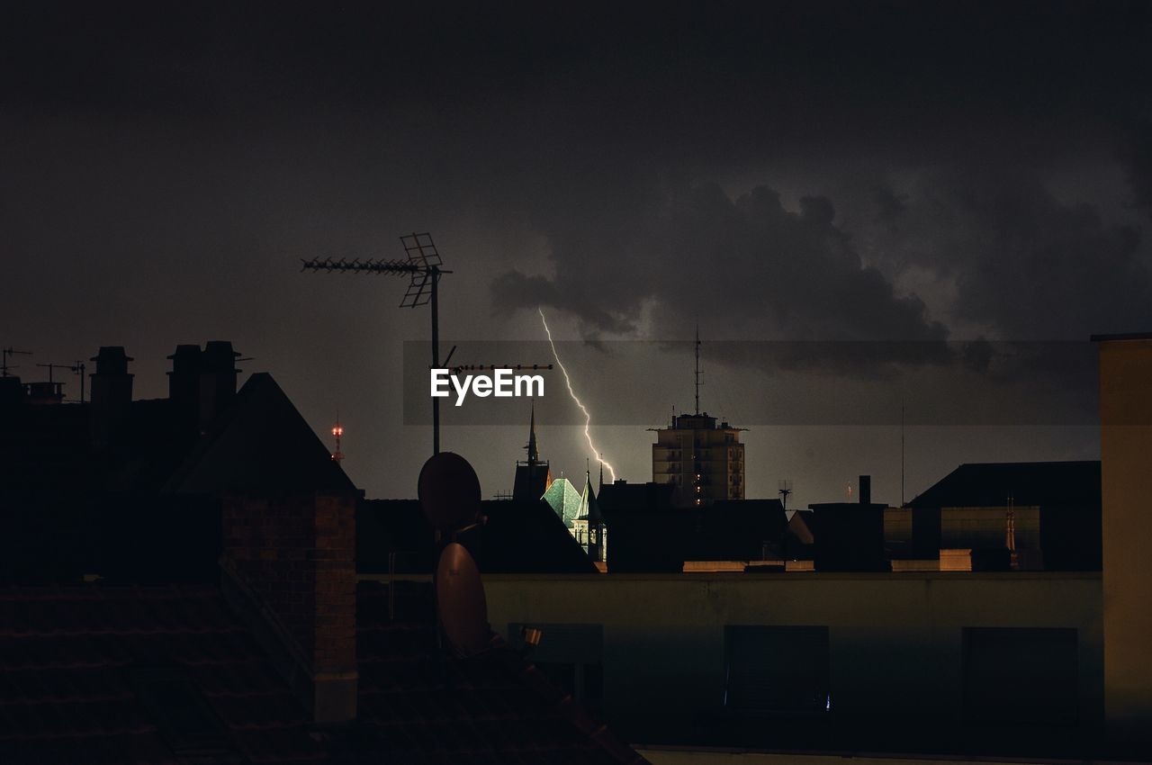 Cityscape against sky during lightning at night