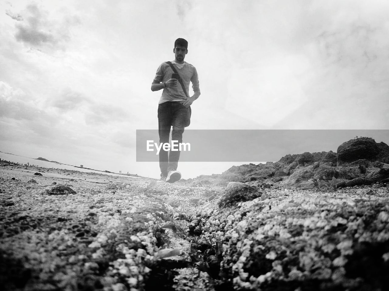 Full length of man walking on beach against sky