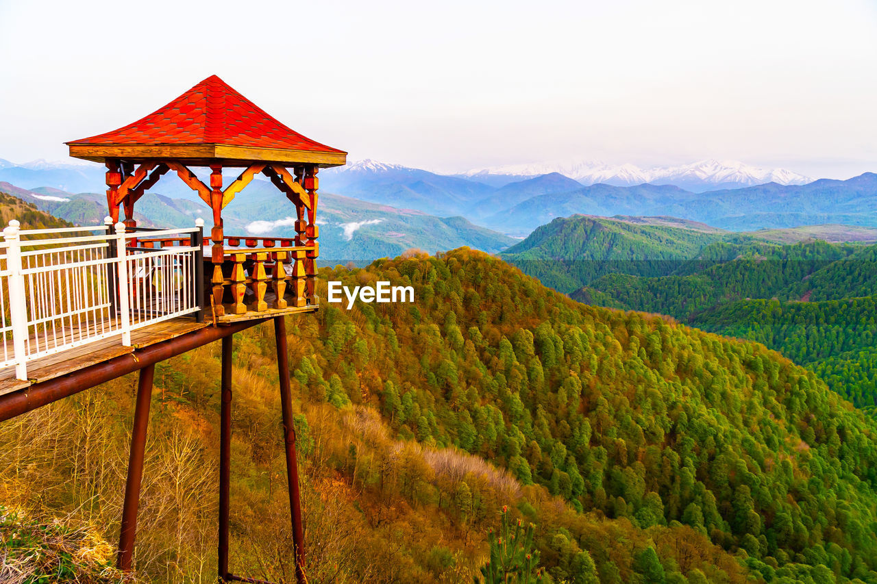 BUILT STRUCTURE BY MOUNTAINS AGAINST SKY