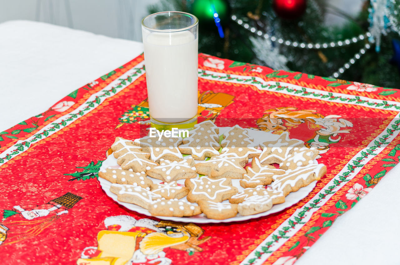 High angle view of gingerbread cookies by drink on table during christmas