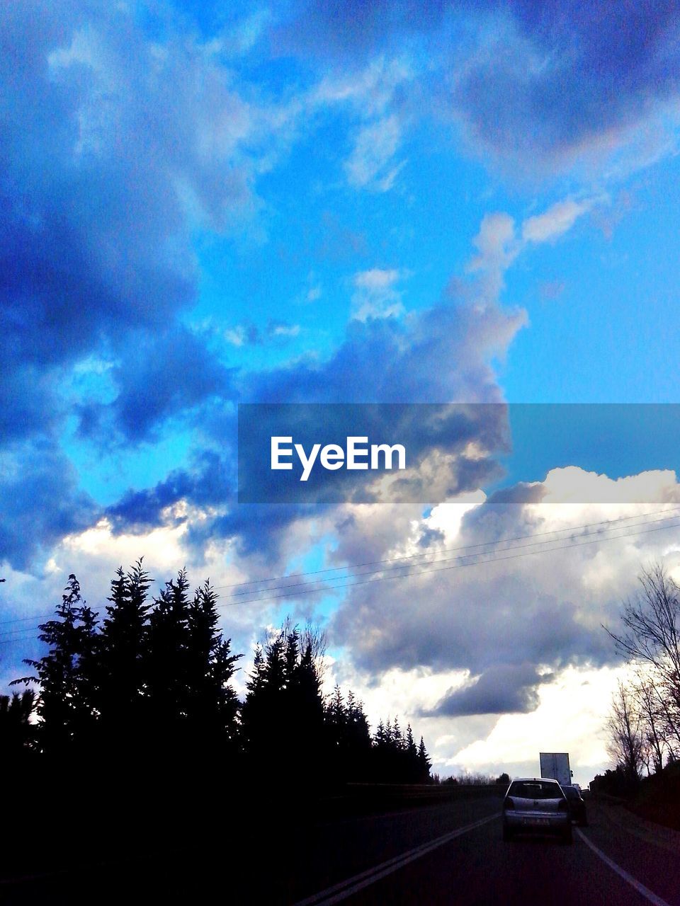 VIEW OF ROAD AGAINST CLOUDY SKY