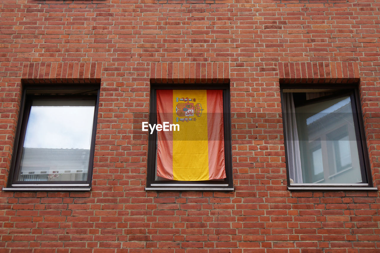 Low angle view of spanish flag in window of building