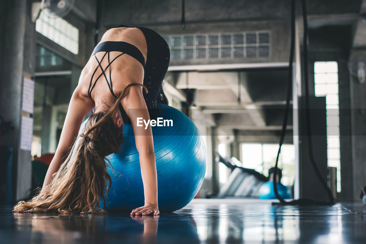 Woman exercising on fitness ball in gym