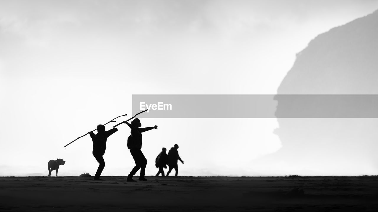 SILHOUETTE PEOPLE ON ROAD AGAINST CLEAR SKY