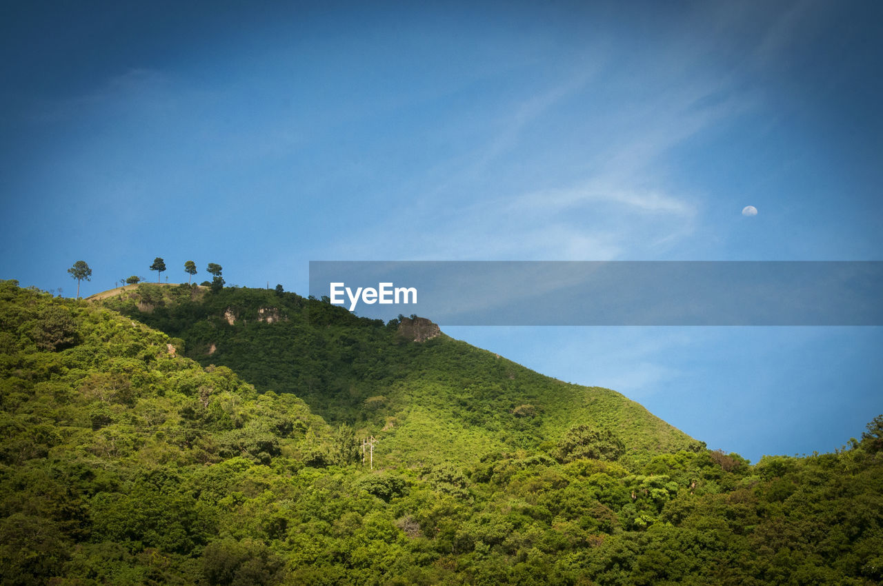 Scenic view of mountains against blue sky