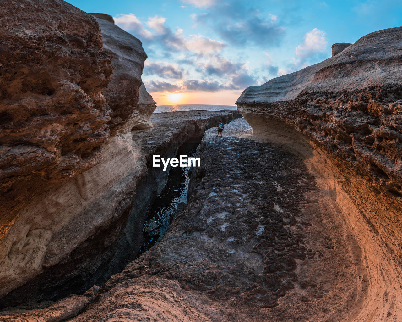 Scenic view of rock formation against sky during sunset