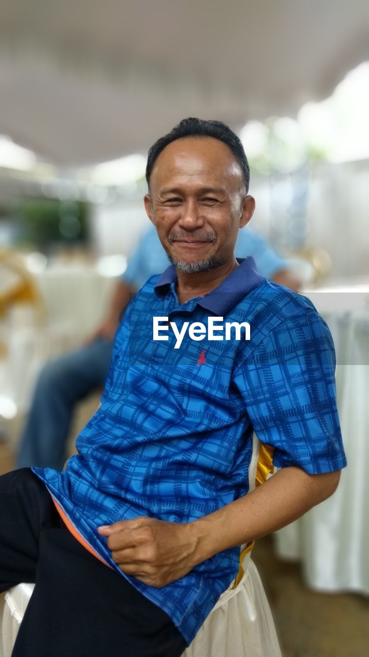 Portrait of smiling man sitting outdoors