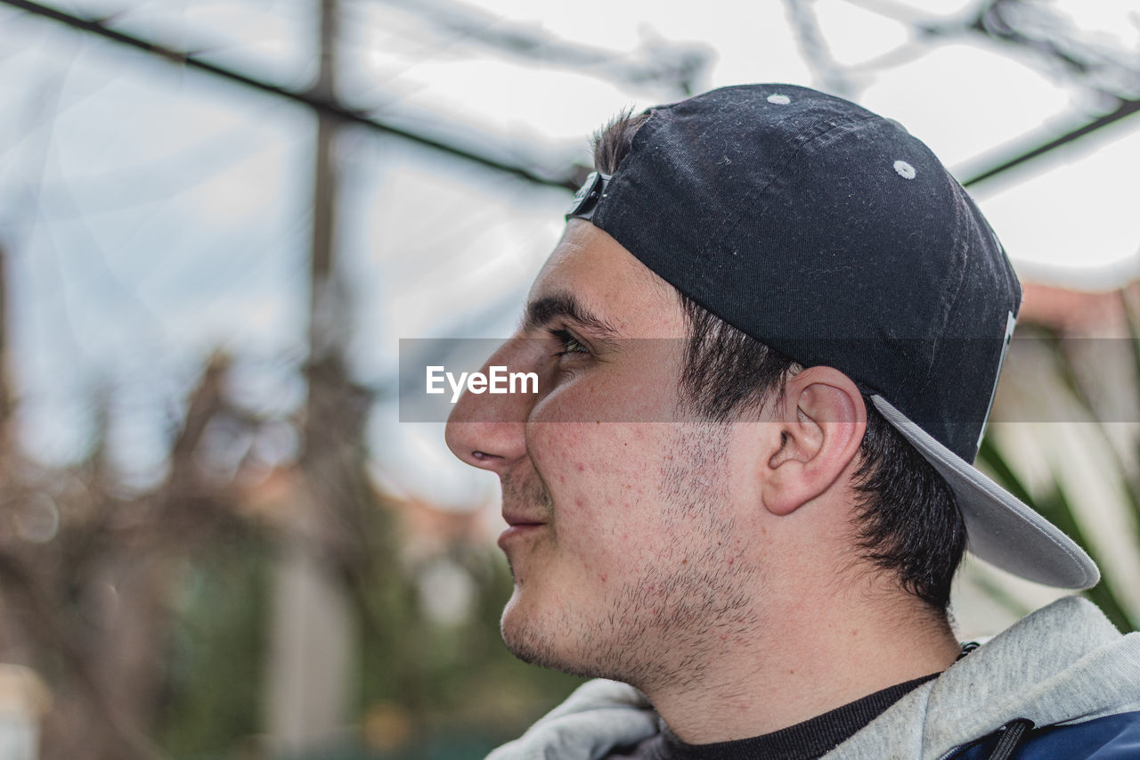 CLOSE-UP PORTRAIT OF YOUNG MAN LOOKING AWAY