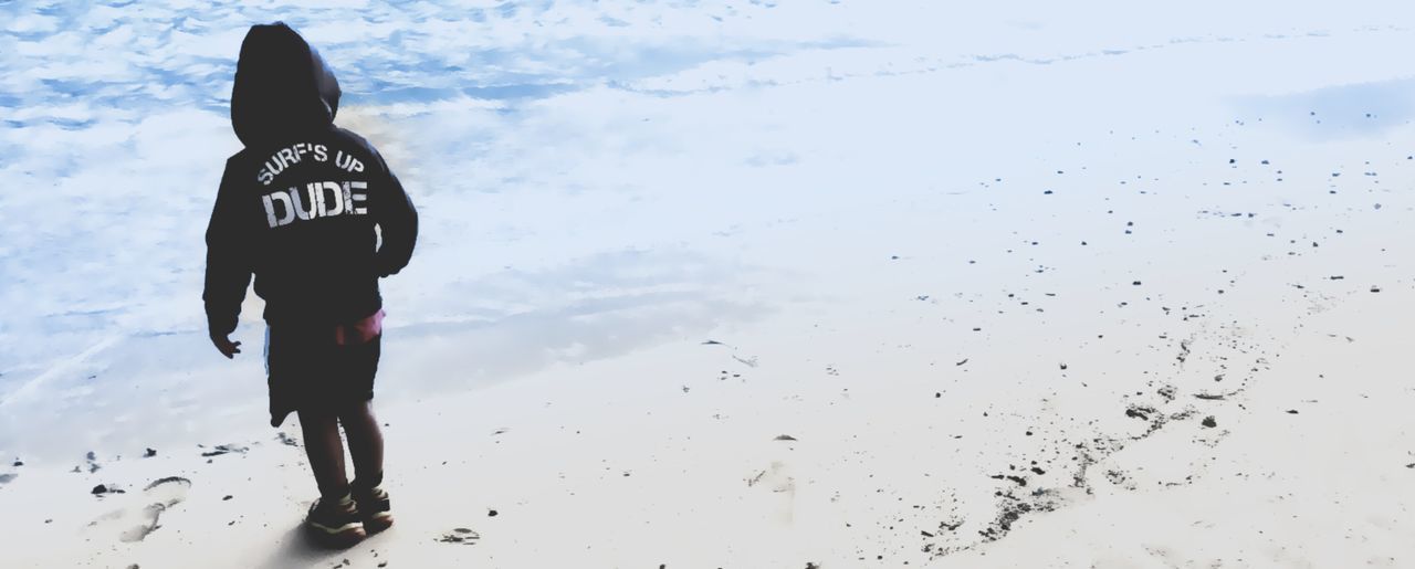 Rear view of boy standing on beach