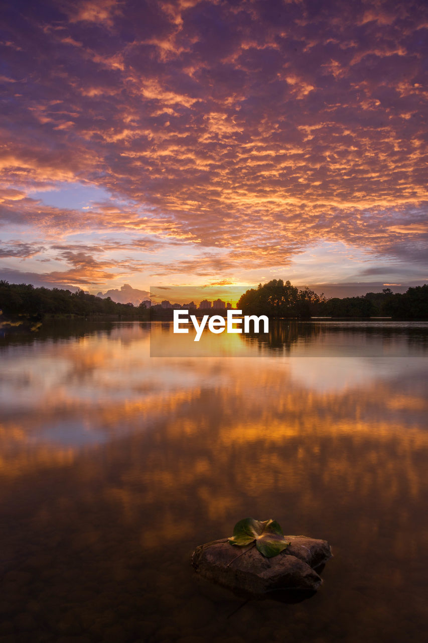 Scenic view of lake against sky at sunset