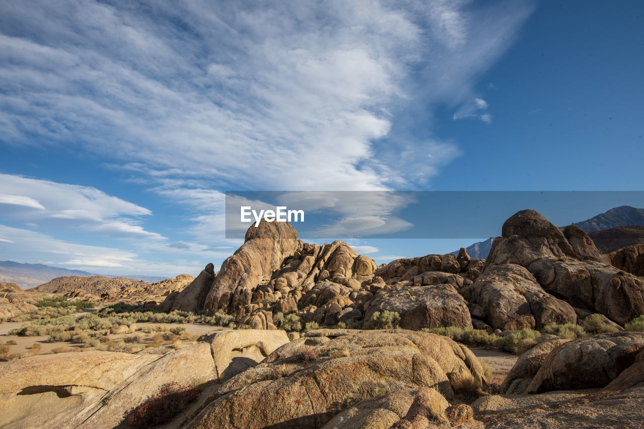 Scenic view of rock formations against sky in desert landscape with cloud formations above