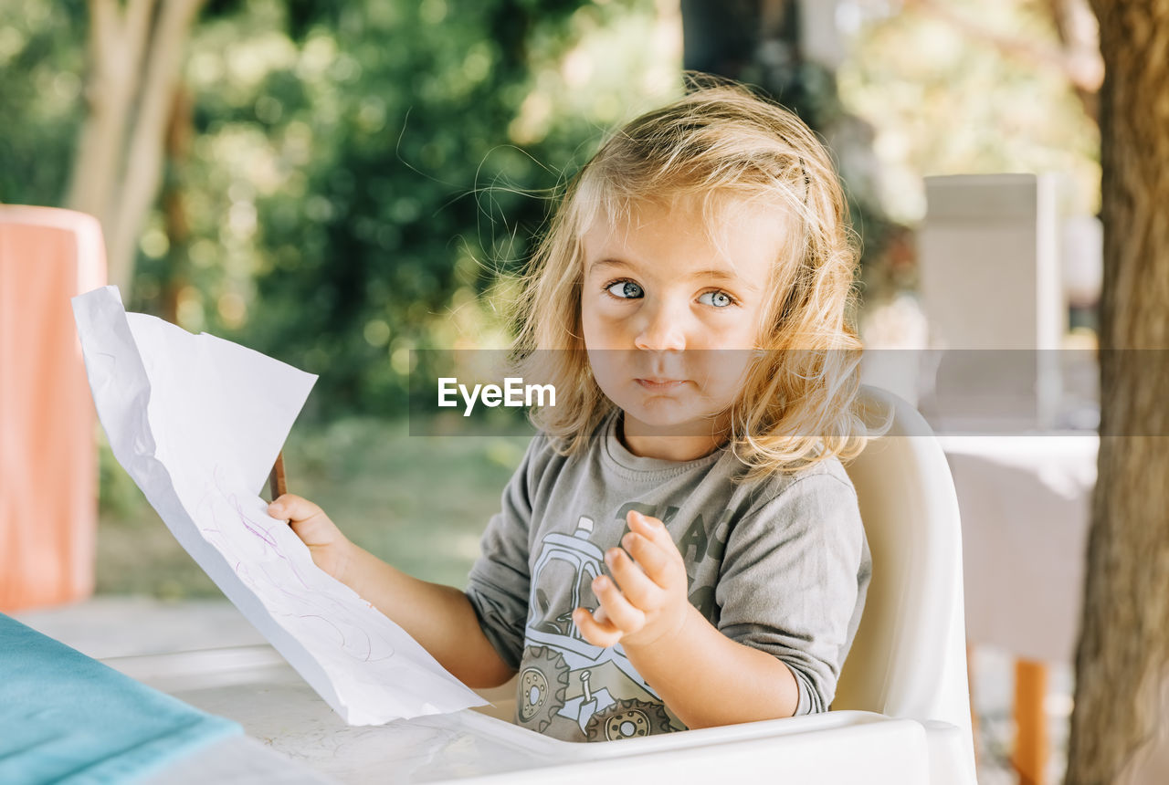 PORTRAIT OF HAPPY WOMAN HOLDING PAPER