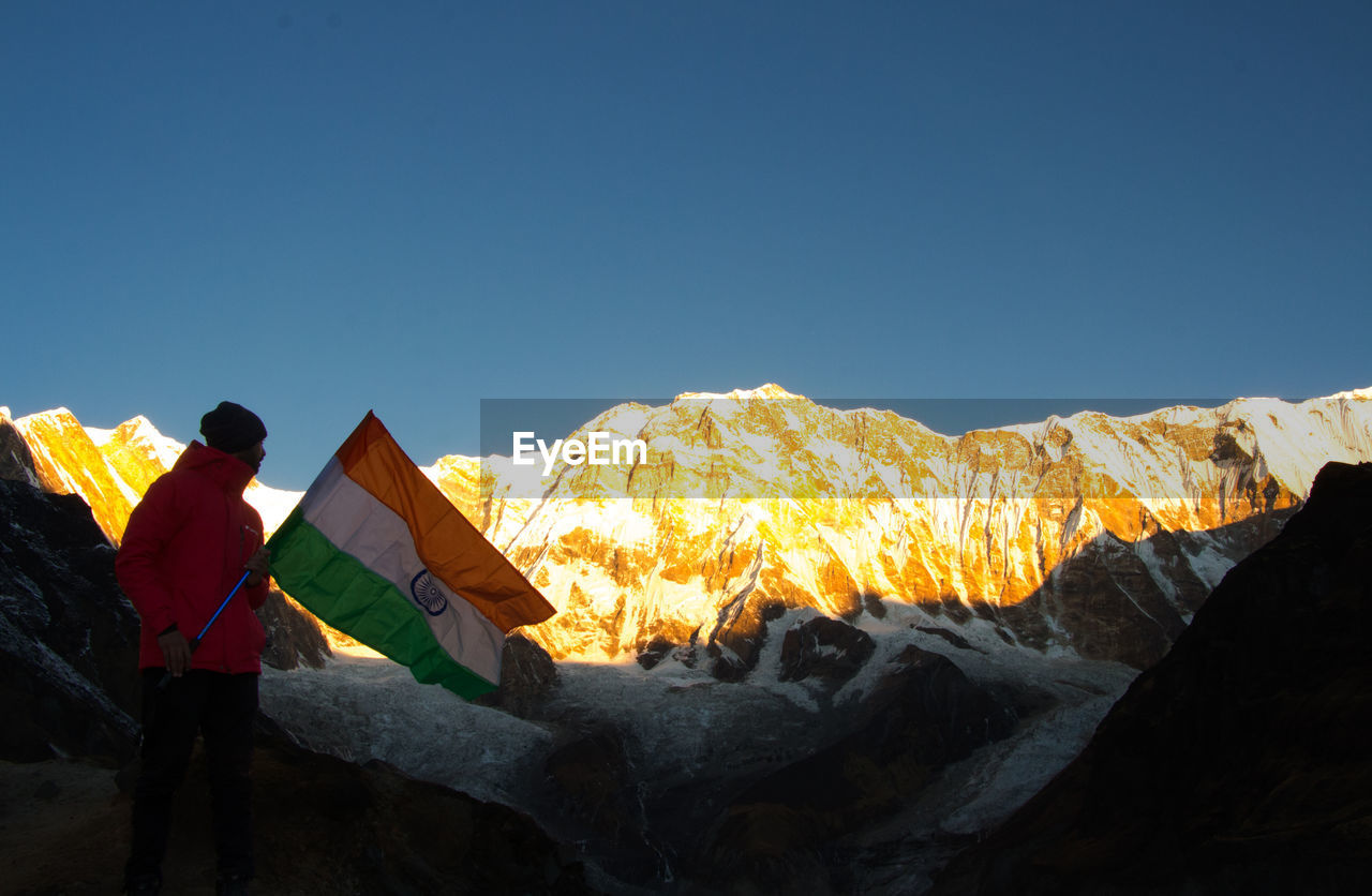 PANORAMIC VIEW OF PEOPLE ON MOUNTAIN AGAINST CLEAR SKY DURING WINTER