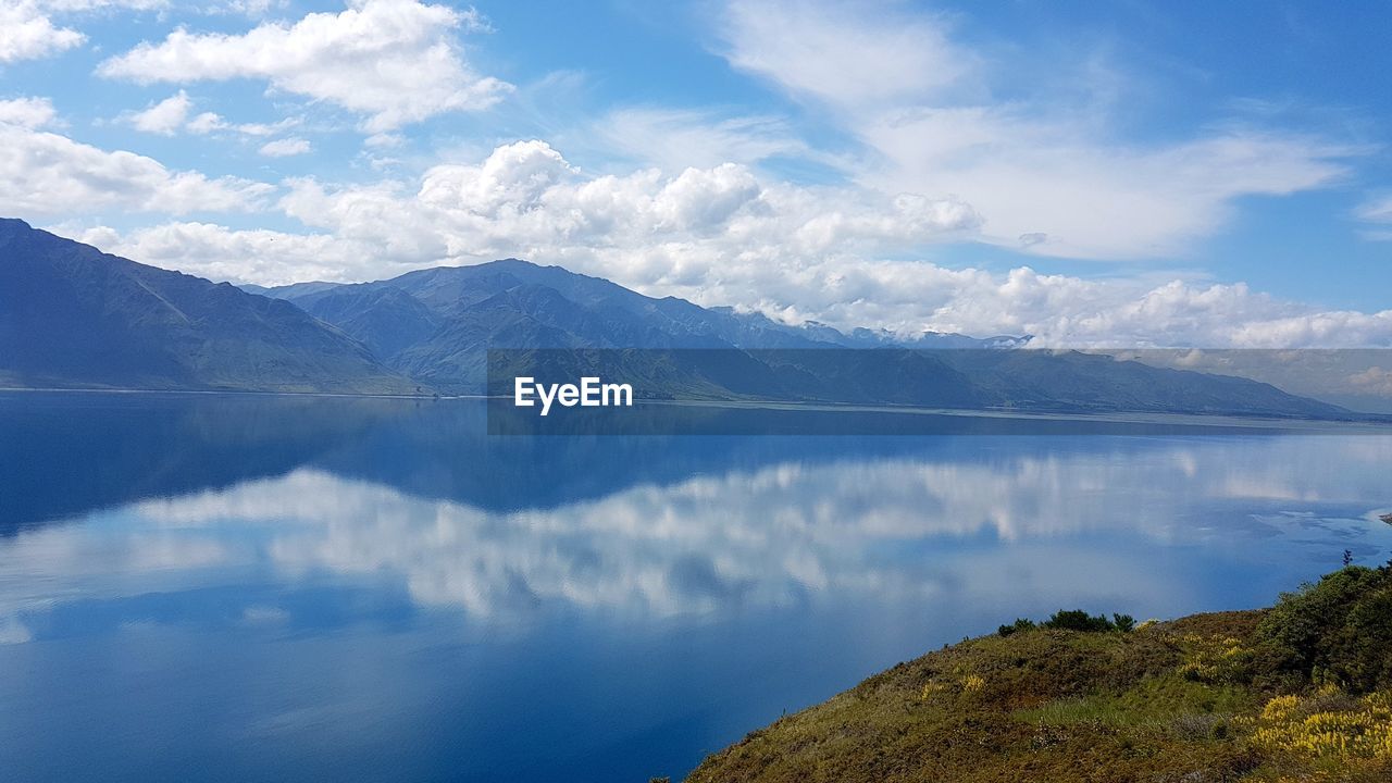 PANORAMIC VIEW OF LAKE AND MOUNTAINS AGAINST SKY