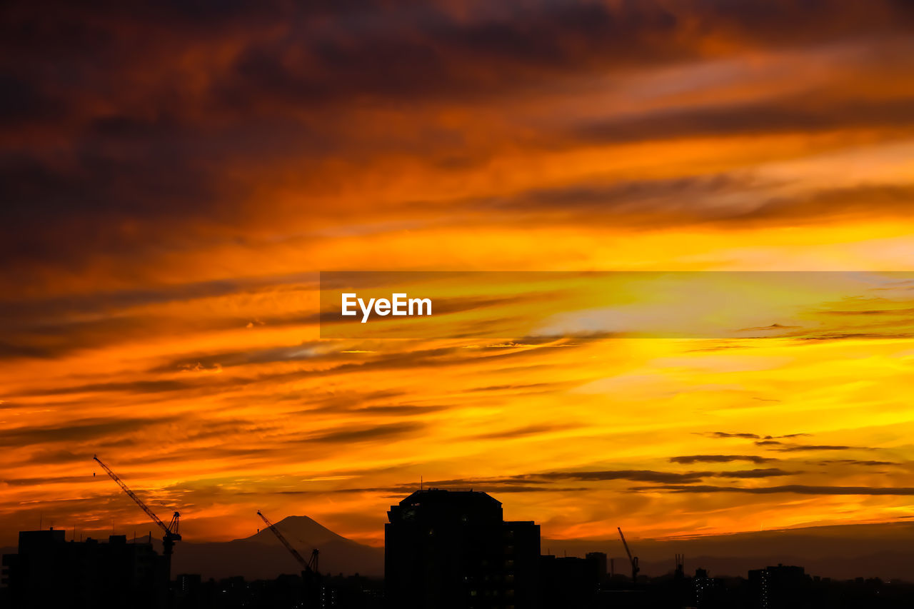 sky, sunset, afterglow, cloud, architecture, silhouette, dramatic sky, red sky at morning, orange color, built structure, building exterior, nature, beauty in nature, horizon, city, no people, dawn, scenics - nature, building, landscape, sun, evening, outdoors, cityscape, tranquility, environment, urban skyline, cloudscape, idyllic, yellow, sunlight, tranquil scene, residential district, travel destinations, moody sky, dark, atmospheric mood