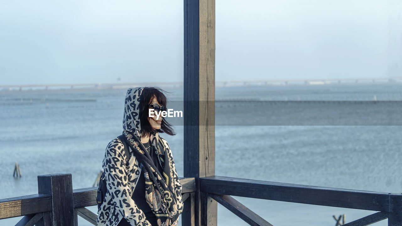 Woman looking at sea against sky