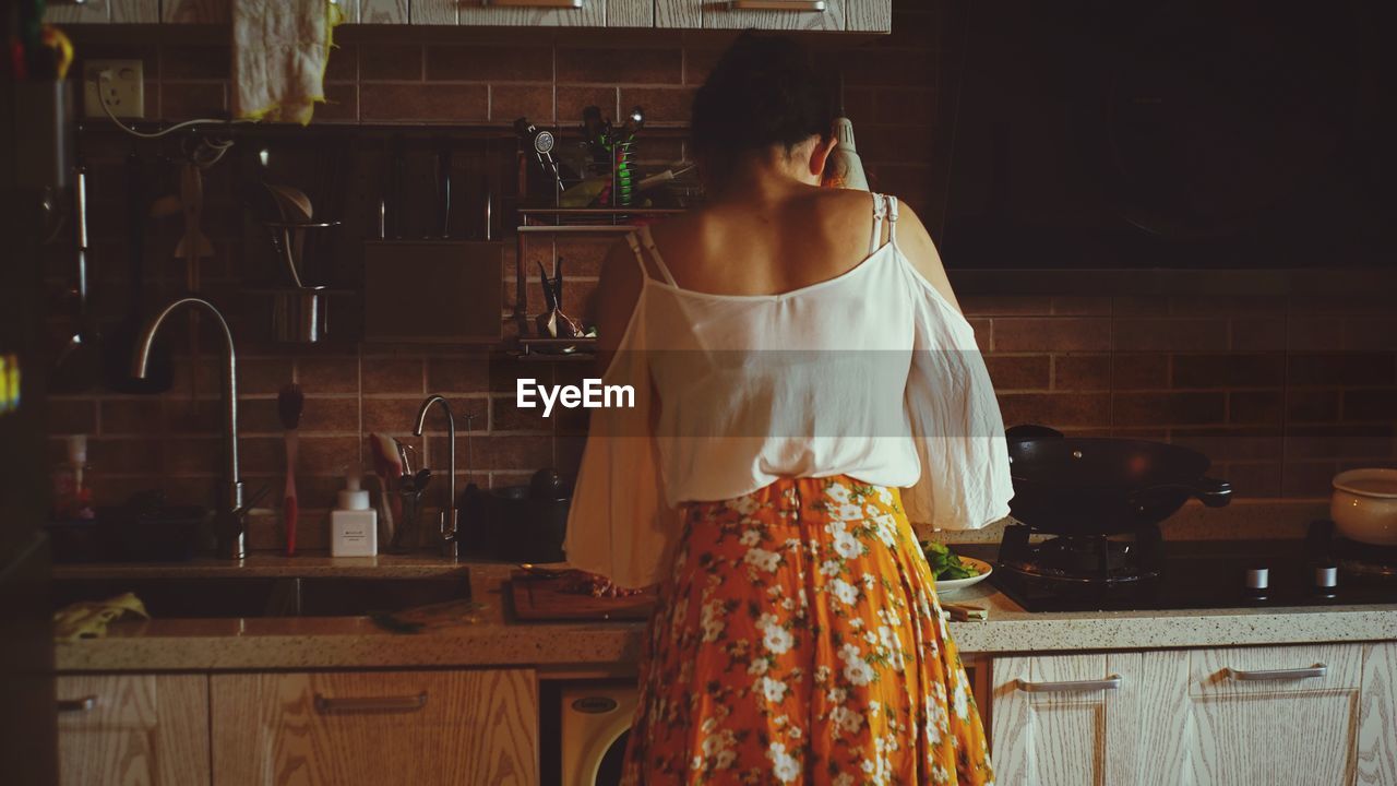 Rear view of woman in kitchen