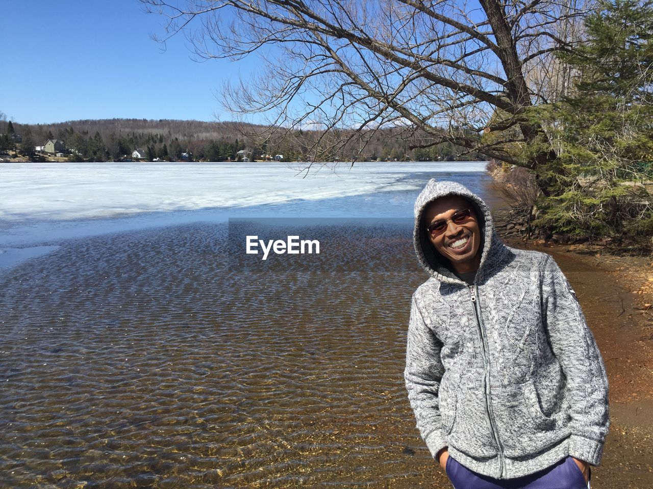 Portrait of smiling man standing by lake