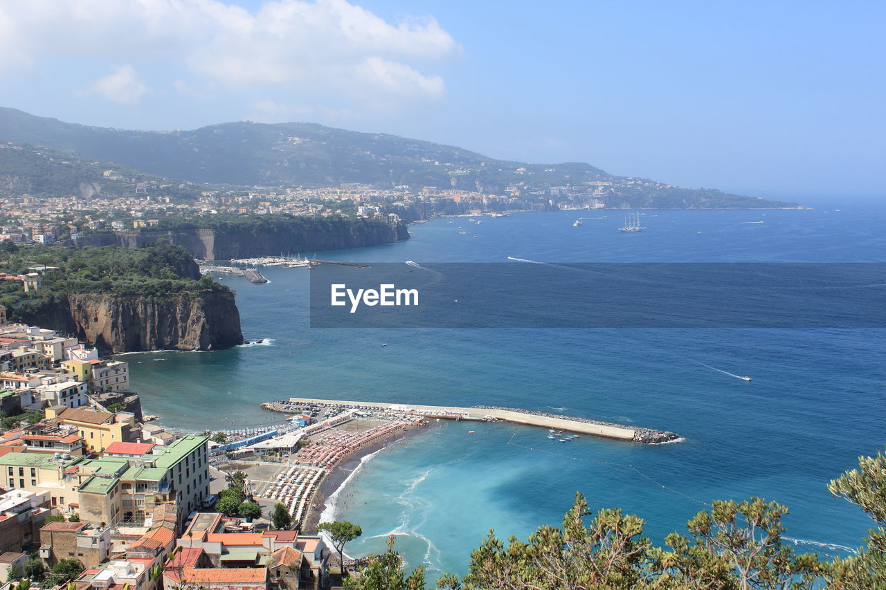 High angle view of townscape by sea against sky