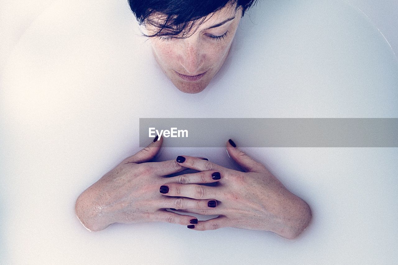 High angle view of woman lying in bath tub