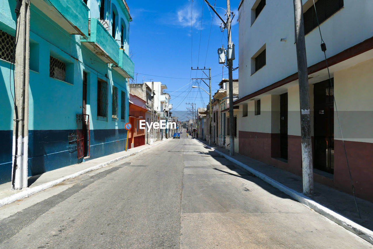 Typical and deserted street of cuba with old cars in direct sunlight