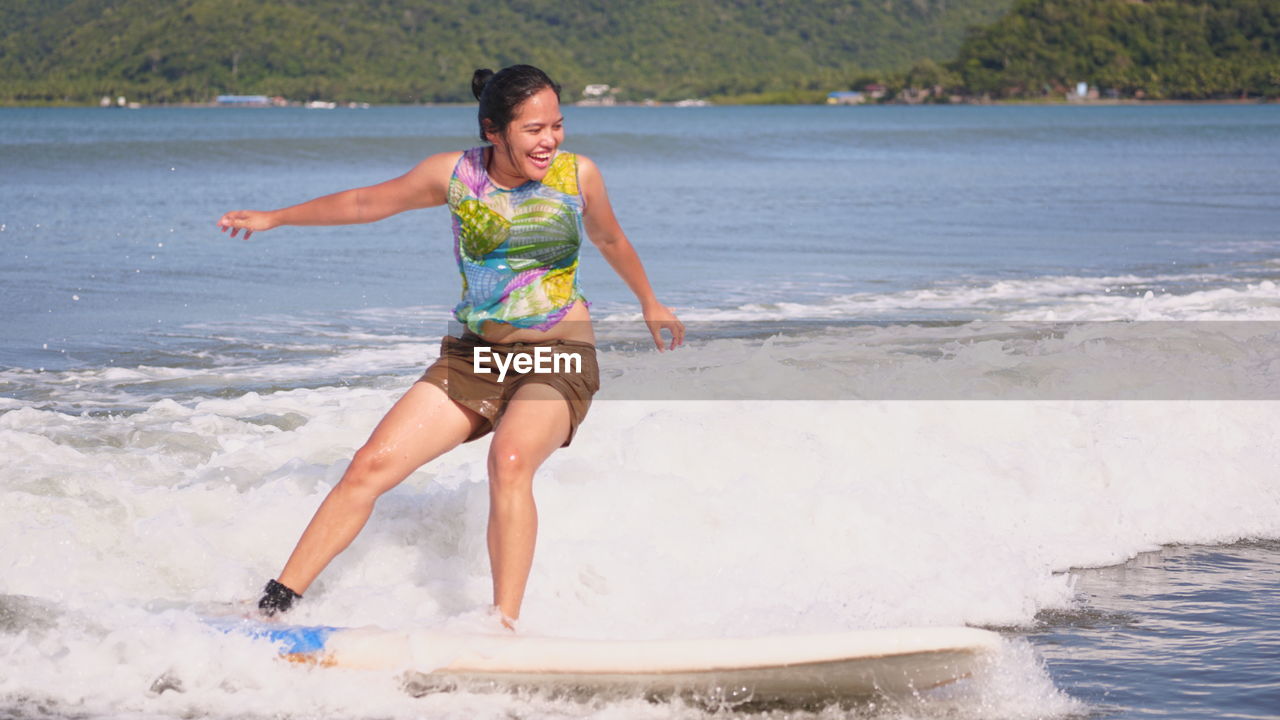Smiling woman surfing in sea