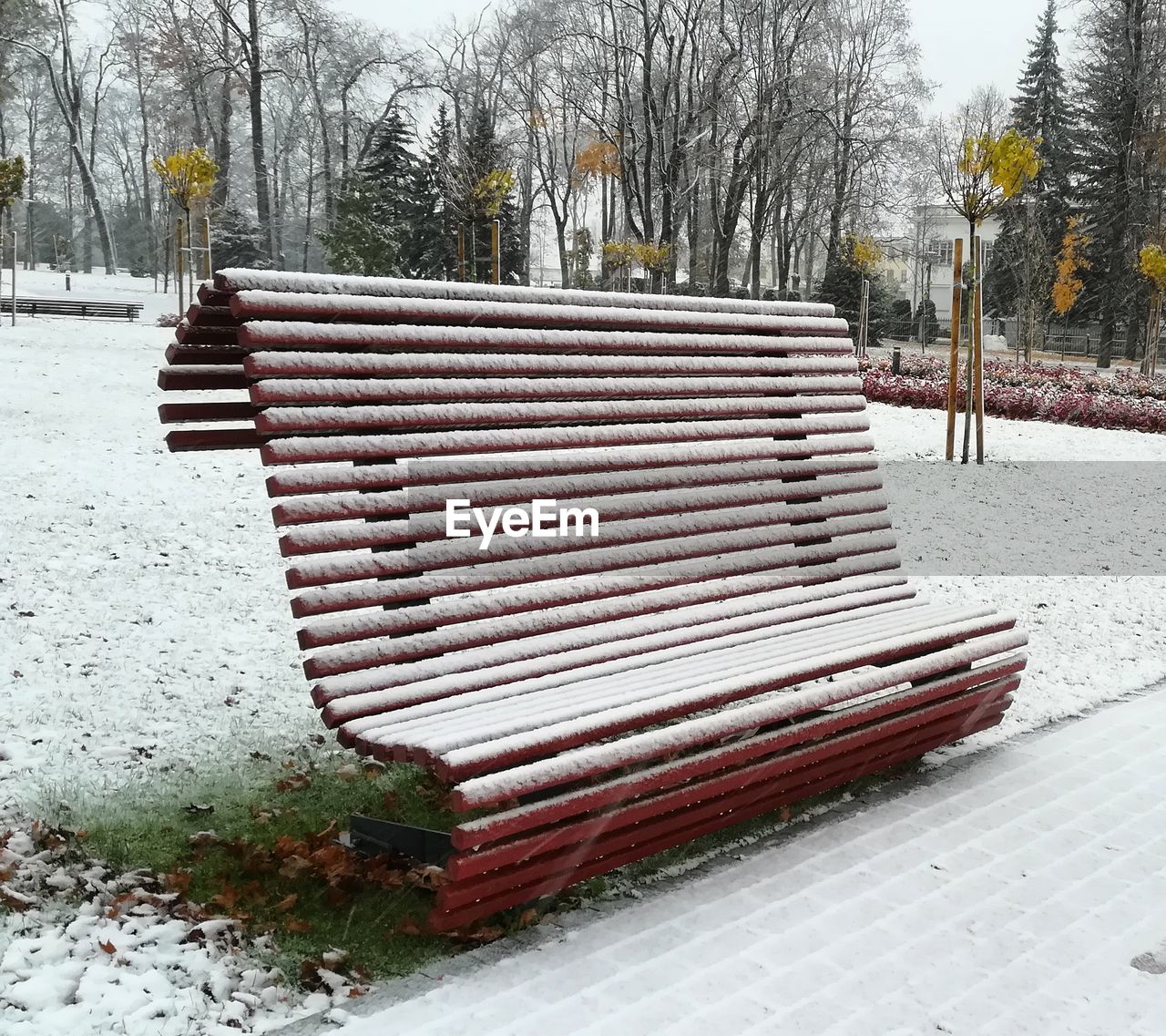 EMPTY BENCH IN SNOW COVERED PARK