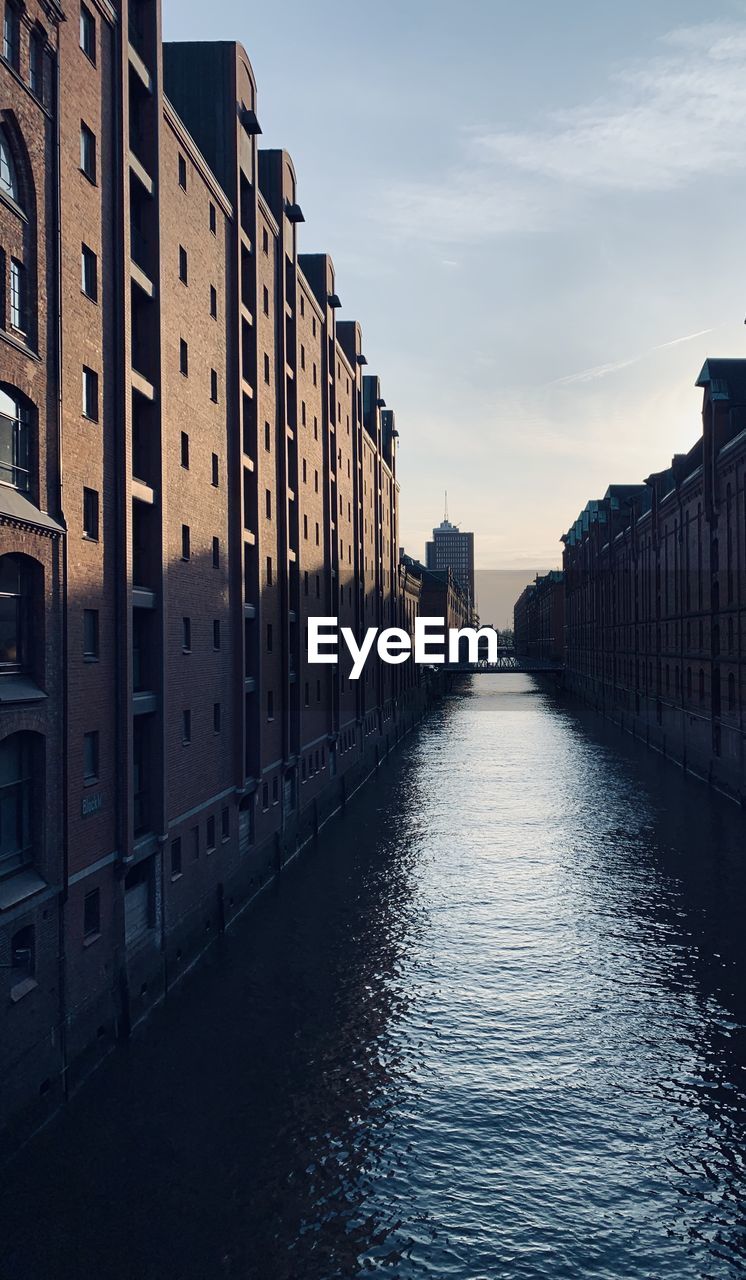 Canal amidst buildings against sky in city in hamburg