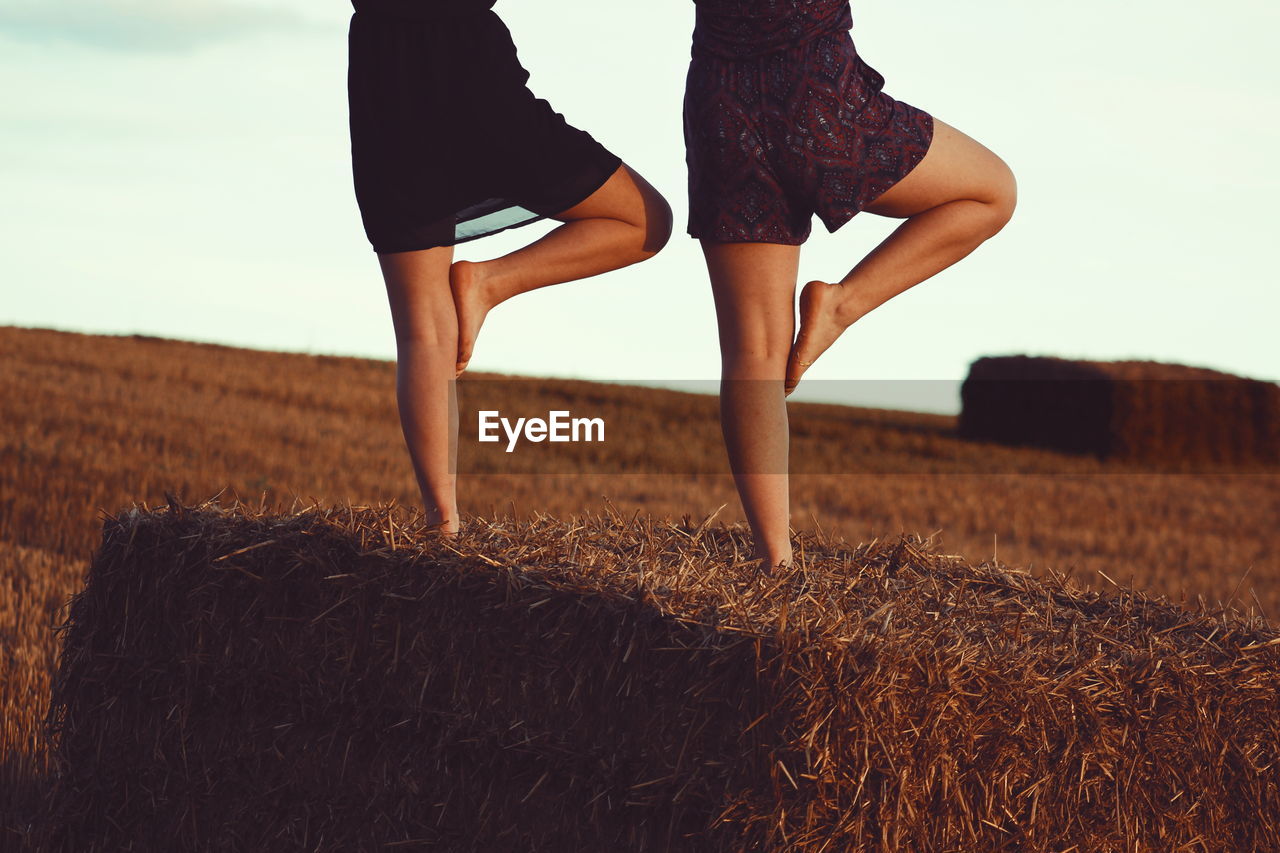 Low section of women exercising on landscape