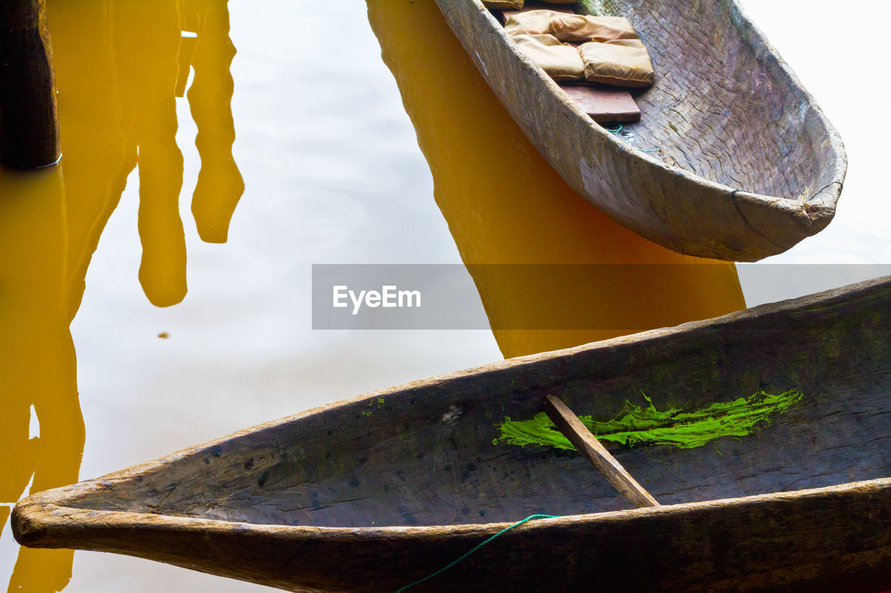 CLOSE-UP OF RUSTY METAL BY BOAT MOORED IN LAKE