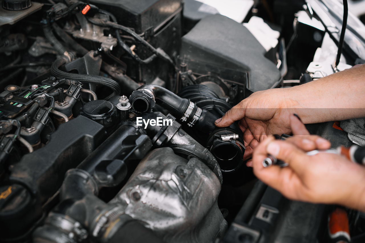 High angle view of man working and repairing car engine