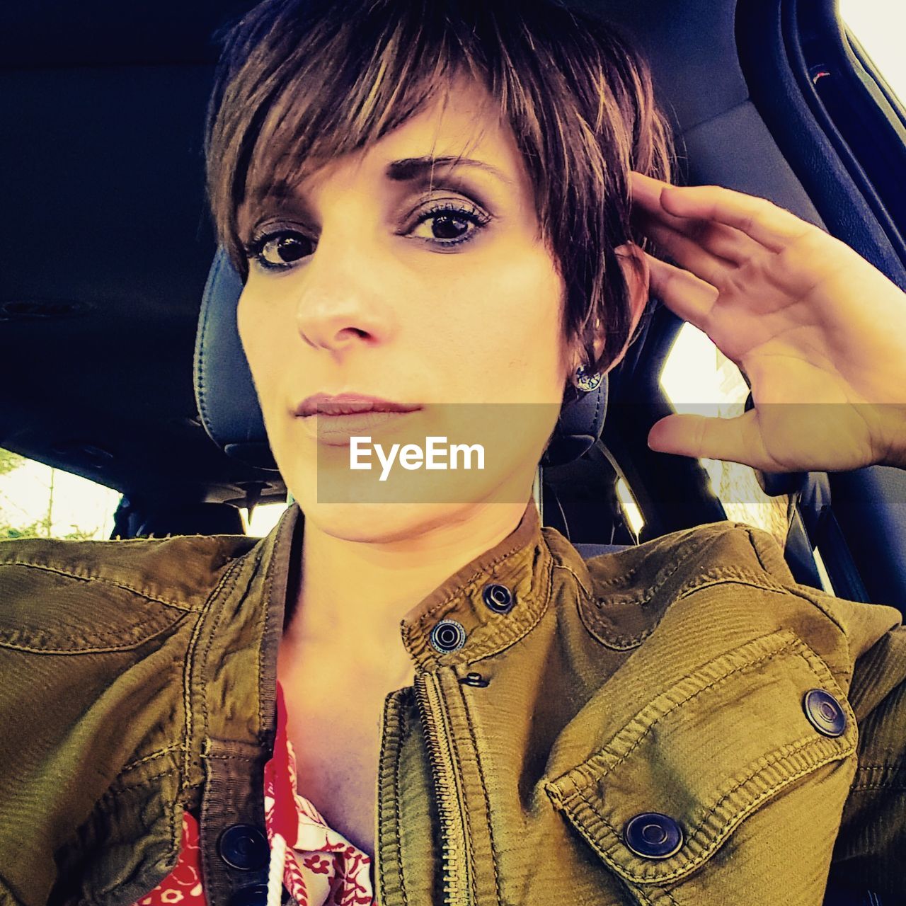 PORTRAIT OF BEAUTIFUL YOUNG WOMAN IN CAR WITH CAMERA