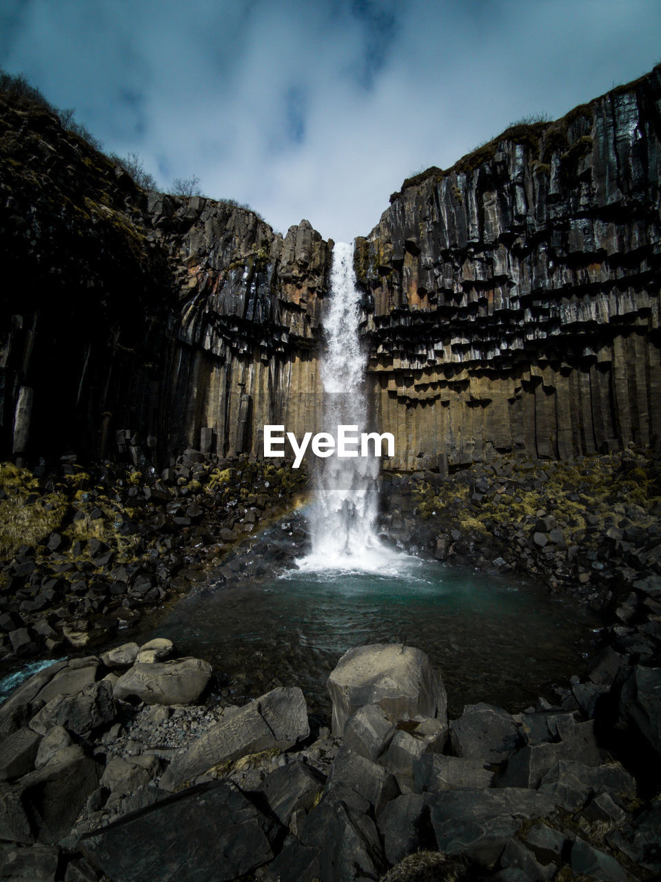 Scenic view of waterfall against sky