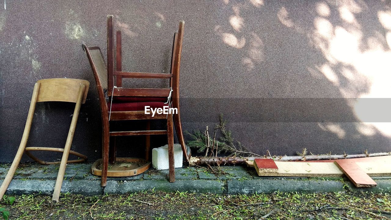 HIGH ANGLE VIEW OF CHAIRS ON TABLE BY WALL