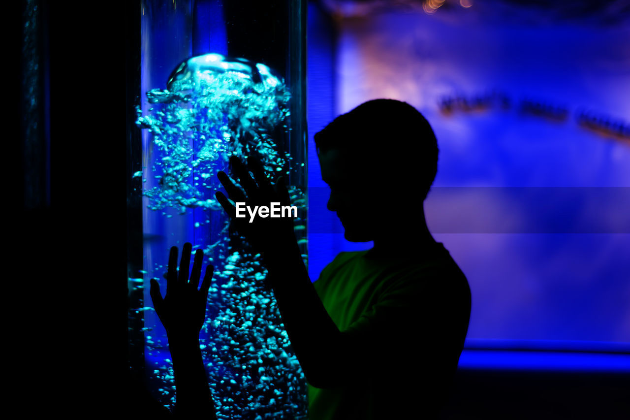 Boy looking jellyfish in tank