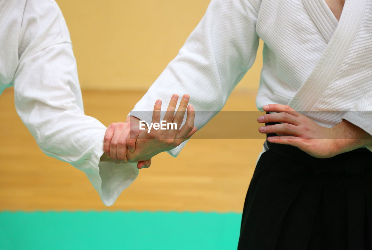 Man with trainer practicing aikido